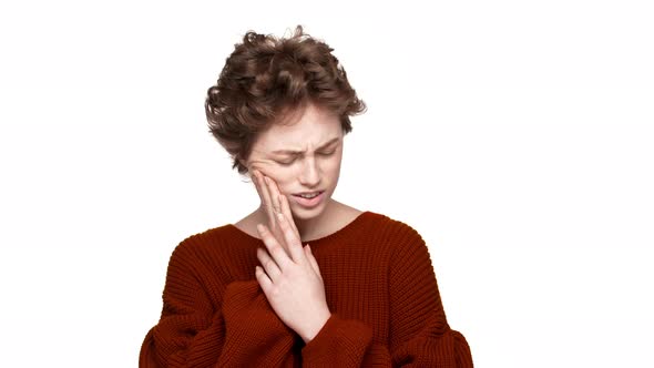 Portrait of Young Woman Suffering From Toothache Touching Cheek and Expressing Pain on Her Face Over