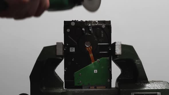 Man Cuts Edge of Hard Disk Drive with Saw in Workshop