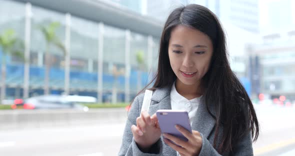 Business woman using smart phone in city