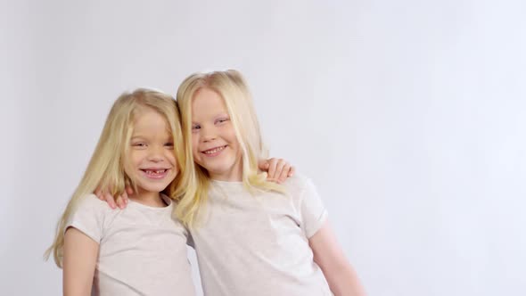 Blonde Twin Girls Hugging and Laughing