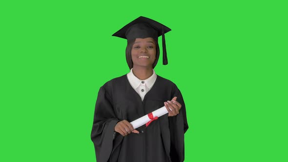 Beautiful Student Smiling While in Her Graduation Cap and Gown on a Green Screen, Chroma Key