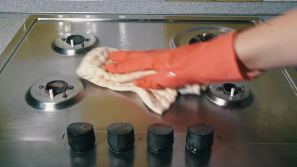 Woman in Gloves Washes and Rubs a Gas Stove with Detergent Until It Shines