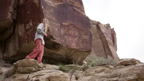 Two young women discovering petroglyphs while hiking