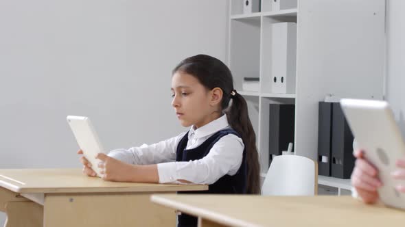 Mixed Race Preteen Schoolgirl Using Tablet in Class