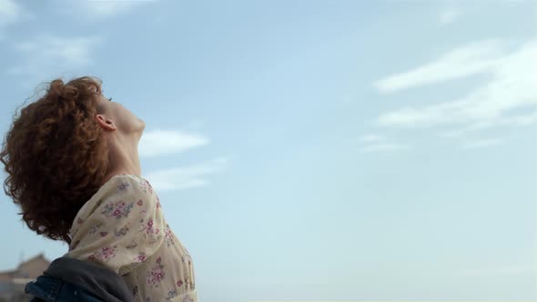 Serene Girl Standing Beach Raising Face to Sunlight Closeup