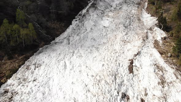 Aerial: drone flying over huge snow avalanche 