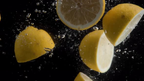 Lemons Falling into Water Super Slowmotion, Black Background, lots of Air Bubbles, 4k240fps