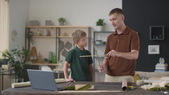 Father And Son Making Kite Together