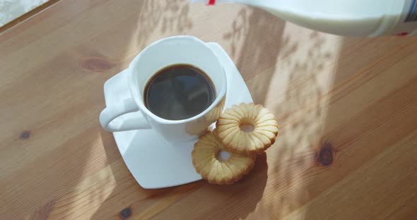 Milk is Poured Into a Cup of Freshly Brewed Coffee