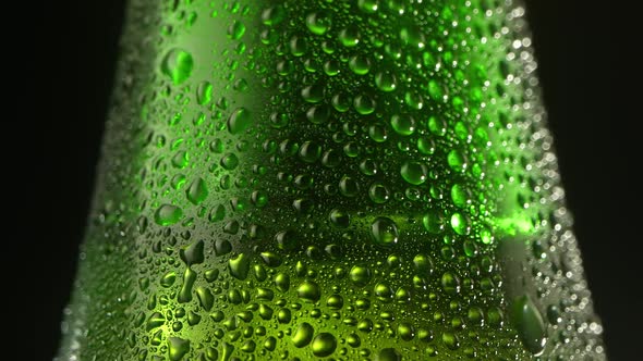 Beer Drop Slowly Trickles Down the Misted Beer Bottle Following the Camera