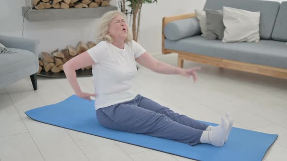 Old Woman Having Back Pain While Doing Yoga at Home