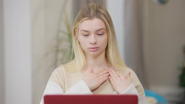 Portrait of Concentrated Young Woman Learning Sign Language Online Gesturing and Looking at Laptop