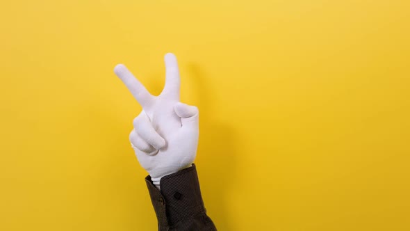 A set of hand gestures in white gloves. Yellow background