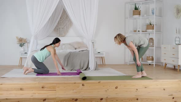 Woman and Private Yoga Trainer Preparing for Exercising Indoors