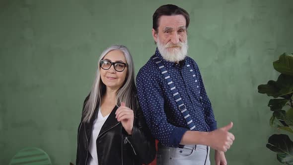 Modern Retired Couple which  Posing on Camera with Thumbs Up