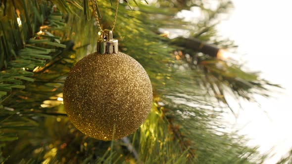 Golden color  bauble on  the Christmas tree 4K 2160p 30fps UltraHD footage - Close-up fairy-lights a