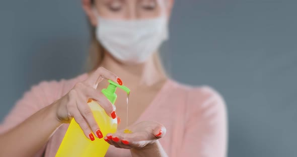 Blurry Lady in Disposable Mask Pours Yellow Liquid Soap