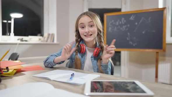 Portrait of Cute Caucasian Girl Blogger Talking and Gesturing Sitting at Desk