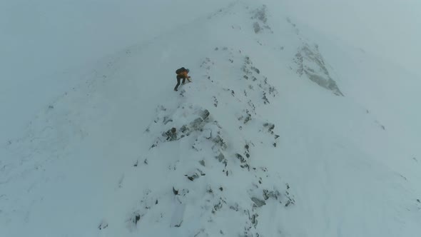 Mountain Climber Traversing a Snowy Rock Face