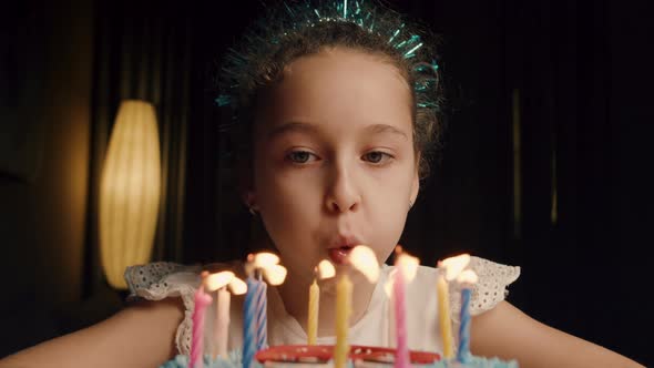 Child Blowing Out Candles on Cake