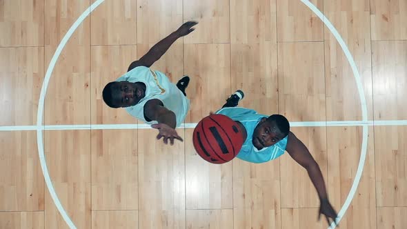 Top View of a Gym with Two African American Players Practicing Basketball