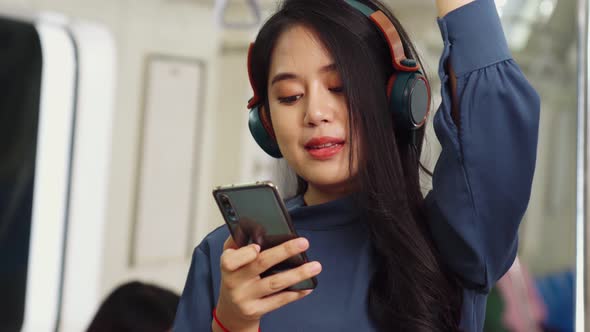 Young Woman Using Mobile Phone on Public Train