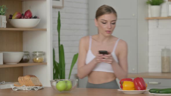 Sporty Woman Taking Picture of Fruits on Smartphone in Kitchen