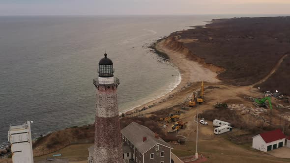 An aerial view of the Montauk lighthouse at sunset. The drone camera truck left and dolly out circli