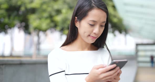 Young Woman look at mobile phone at outdoor