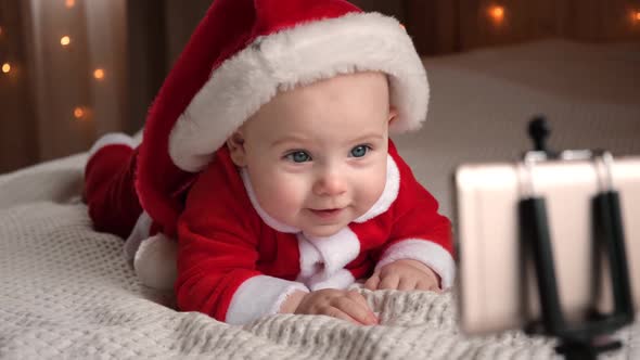 Smiling Baby in Santa Claus Costume Dancing and Making Video Call