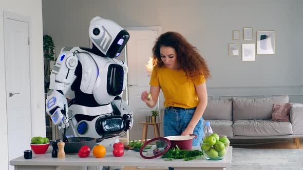 White Robot and Woman Cook Dinner Together. Cyborg and Human Concept.