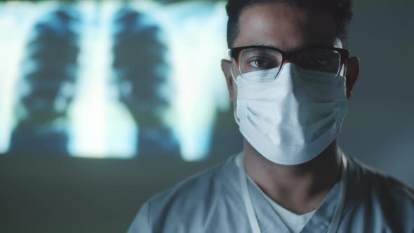 Portrait of Middle Eastern Doctor in Mask in Dark Room