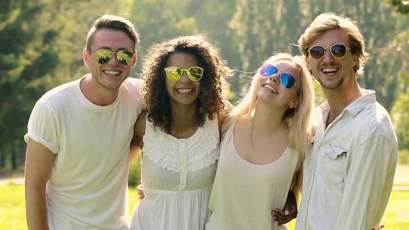 Multiethnic Group of People in Sunglasses Smiling Cheerfully, Waving Hands