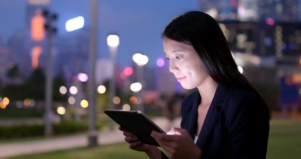 Business woman use of tablet computer at night