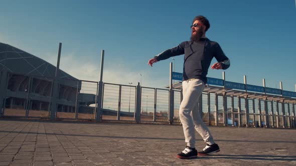 Young Handsome Brutal Bearded Man Running with a Backpack, Autumn Day, Funny Style