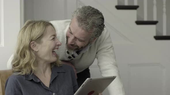 Senior Adult couple working from home on laptop