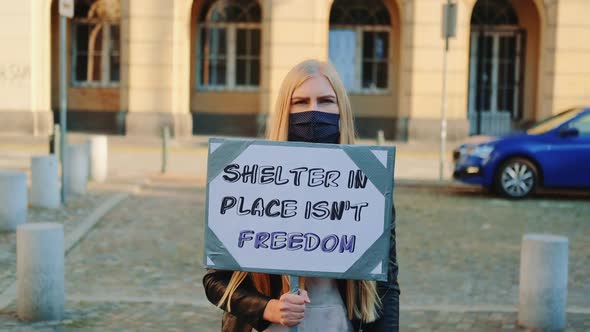 Woman in Mask Protesting That Shelter in Place Does Not Mean Freedom