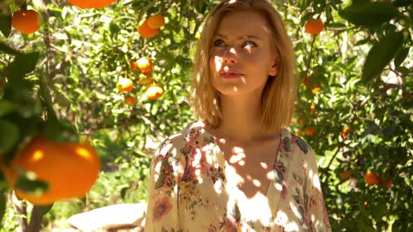 Young Lady Looking Around at the Oranges on an Early Morning Walk