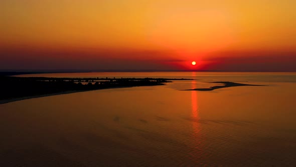 4K UHD Aerial drone view Beautiful sunset over tropical beach with clouds In the middle of the sea