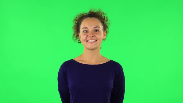 Portrait of Curly Woman Smiling While Looking at Camera. Green Screen