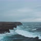 Wild ocean waves crashing againt coastal cliffs and into the caves shot by drone - VideoHive Item for Sale
