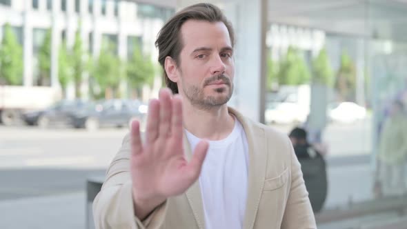 Stressed Young Man Showing Stop Gesture Outdoor