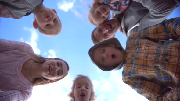 Happy Young Family with Children Opens the Box and Rejoices Against the Blue Sky.