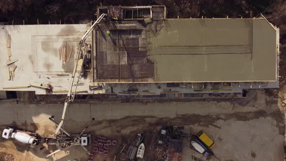 Concrete Cement on the Roof of Building Under Construction Using a Concrete Pump Truck Machine