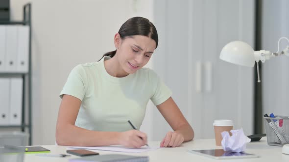 Frustrated Young Latin Woman Failing To Write on Paper 