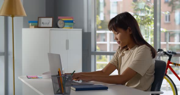 Side View of Asian School Girl Student Distance Learning on Laptop