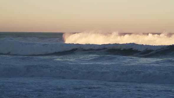 Ocean Waves Breaking Background in Dramatic Orange Sunset Light, Sea Crashing Below Horizon from Low