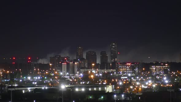 Time lapse of beautiful night cityscape with burning fire smoke at the background.