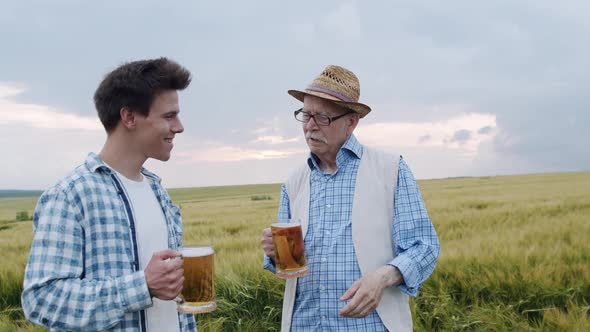 Farmer with Son Clinking with Pints and Drinking with Joy in Barley Field