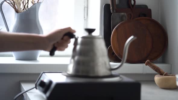 Woman putting coffee kettle on stove